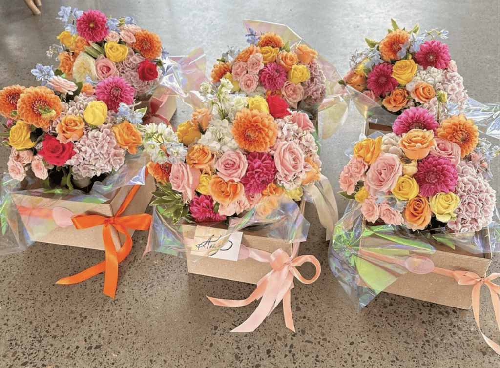 A group of bridal party bouquets created by Flowers by Julia G in colours of peach, lemon, orange, pink and raspberry.